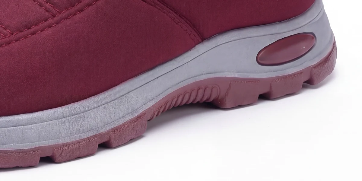 La suola alta della scarpa rosso vino vista di lato, con il battistrada